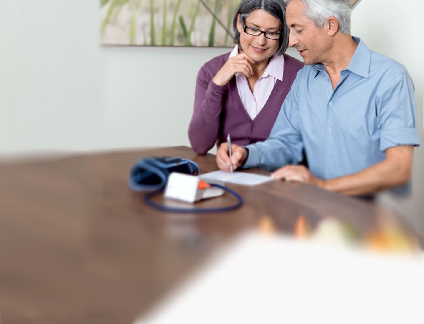 Älteres Paar schreibt aktuelle Blutdruckwerte auf