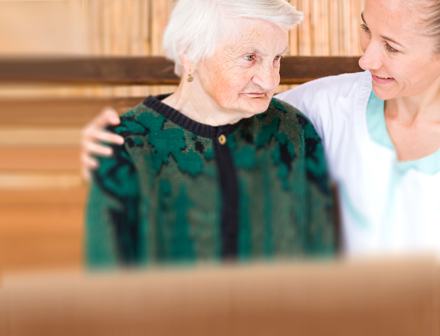 Pflegerin im Gespräch mit dementer Seniorin