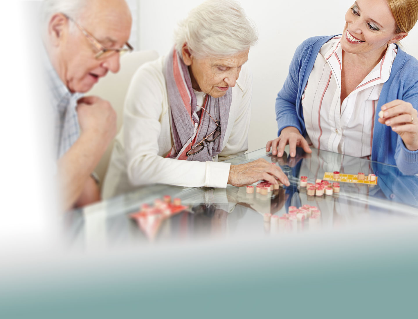 Seniorenpaar mit Pflegekraft beim Spielen