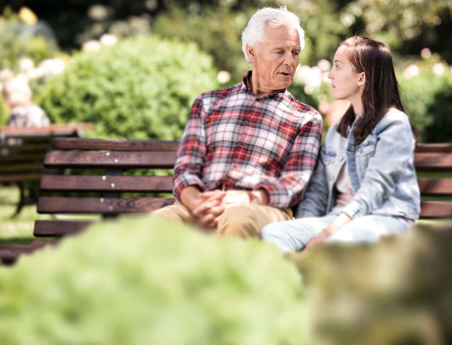 Senior mit Enkelin auf einer Bank