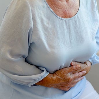 Ältere Dame mit Bauchkrämpfen