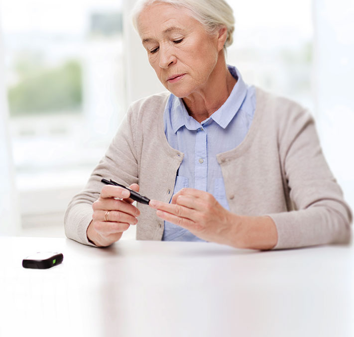 Seniorin misst Blutzuckerspiegel