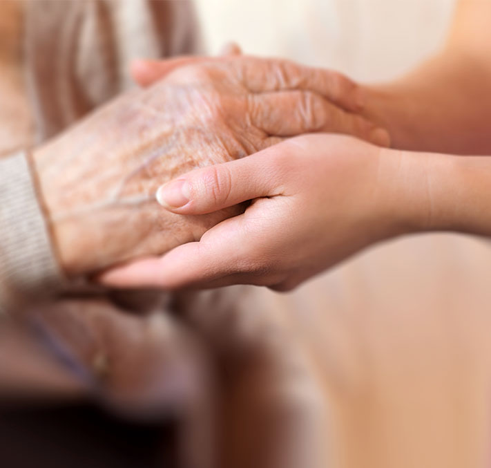 Ältere und junge Hände halten sich gegenseitig