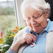 Seniorin mit Notruftaste um den Hals