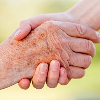 Ältere Hand gibt jüngerem die Hand