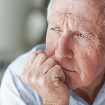 Deprimierter Senior stützt Kopf mit Hand