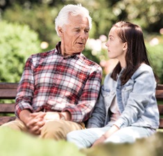 Senior mit Enkelin auf einer Bank
