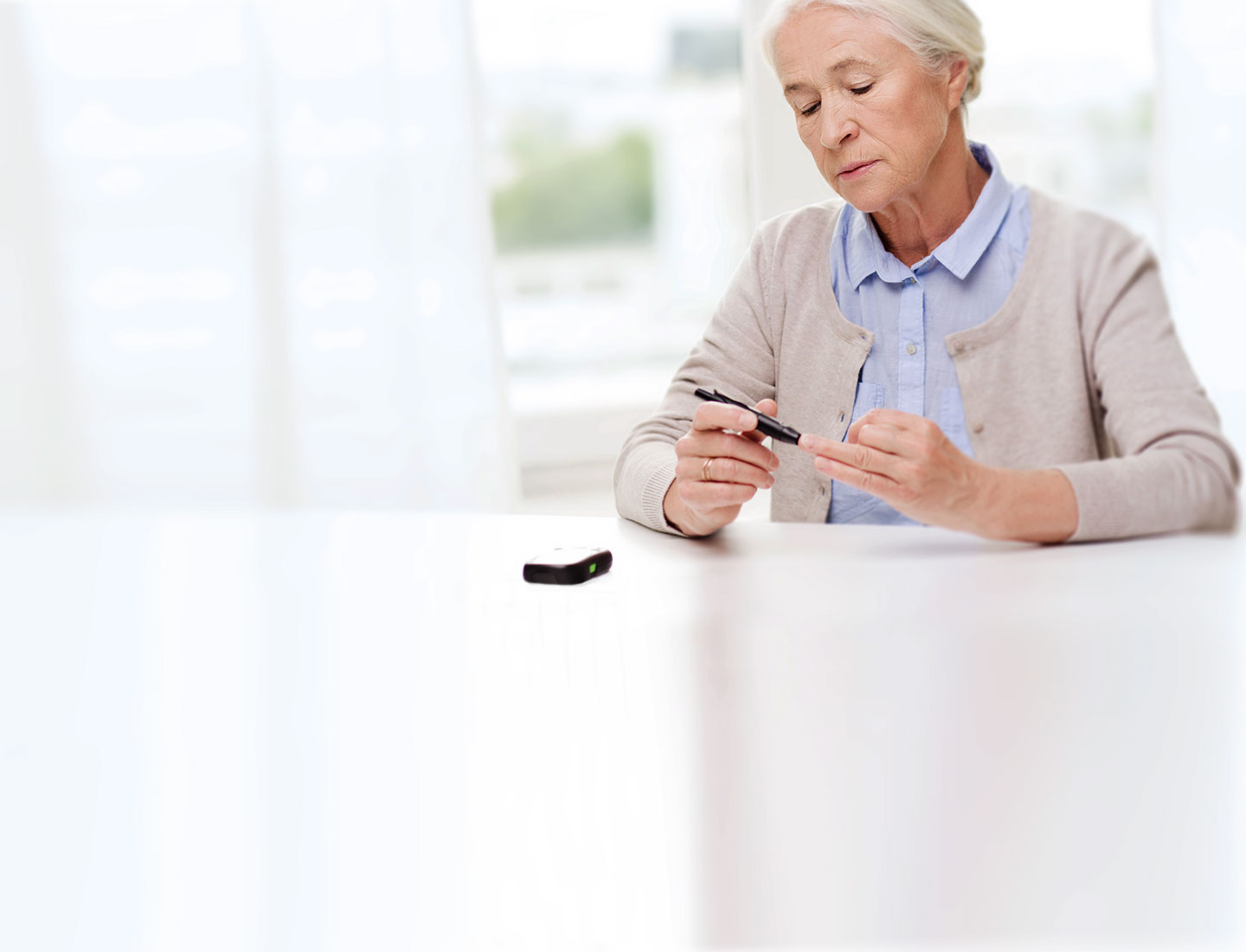 Seniorin misst Blutzuckerspiegel