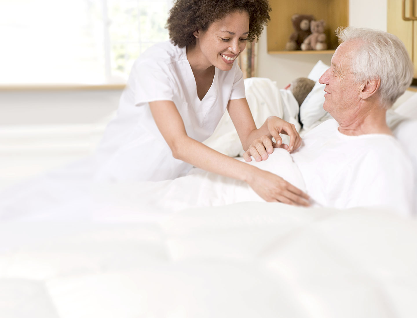 Pflegerin kümmert sich um Mann im höheren Alter