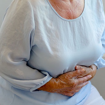 Ältere Dame mit Bauchkrämpfen