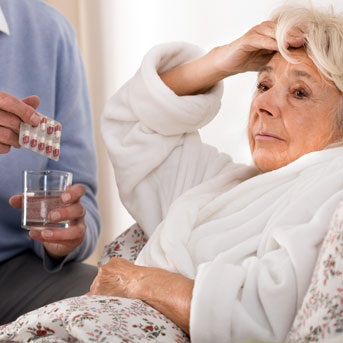 Seniorin mit Fieber im Bett 