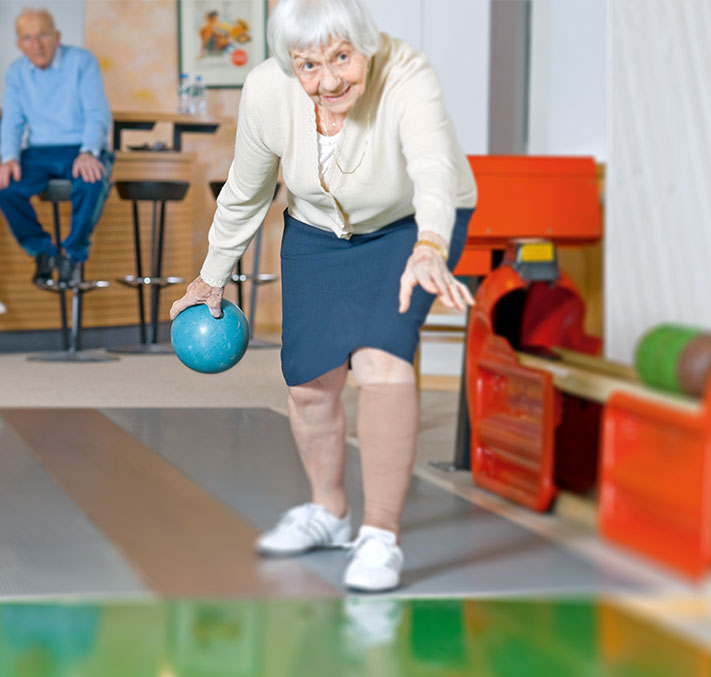 Ältere Frau beim Kegeln mit Stützstrümpfen