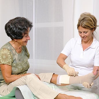 Verbandwechsel bei älterer Dame durch Pflegerin