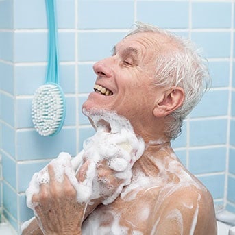 Senior schäumt sich ein und pflegt damit seine Haut