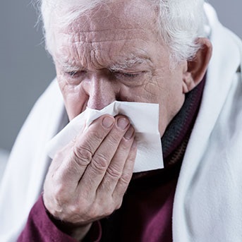 Kranker Senior mit Taschentuch