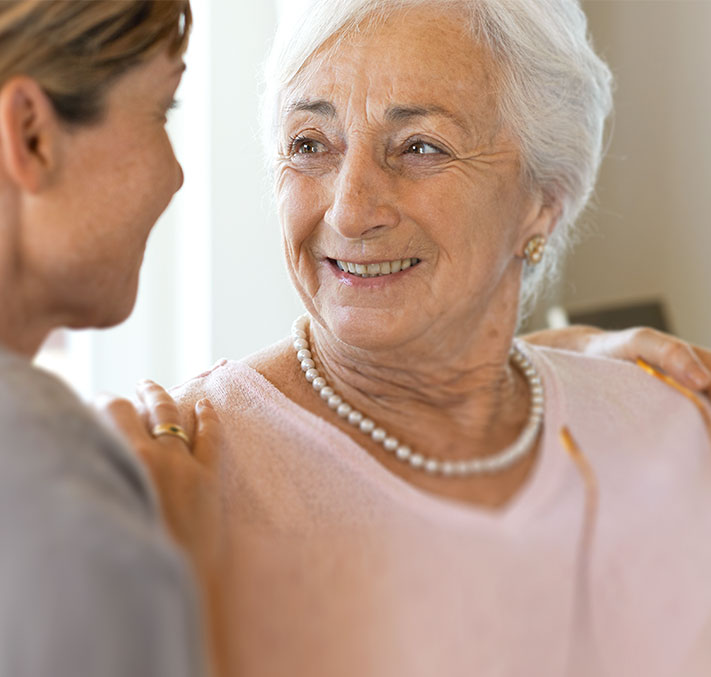 Seniorin wird von Tochter in Arm genommen