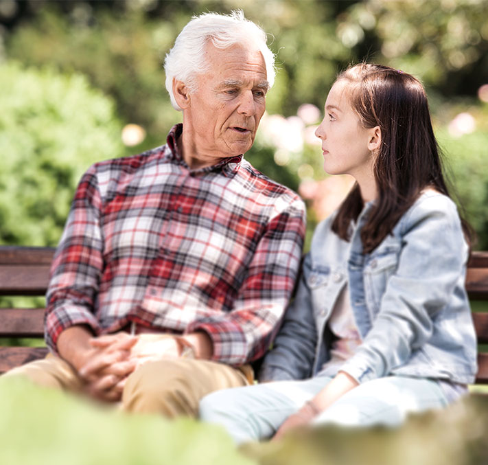 Senior mit Enkelin auf einer Bank