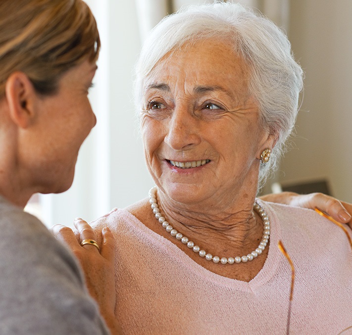 Seniorin wird von Tochter in Arm genommen