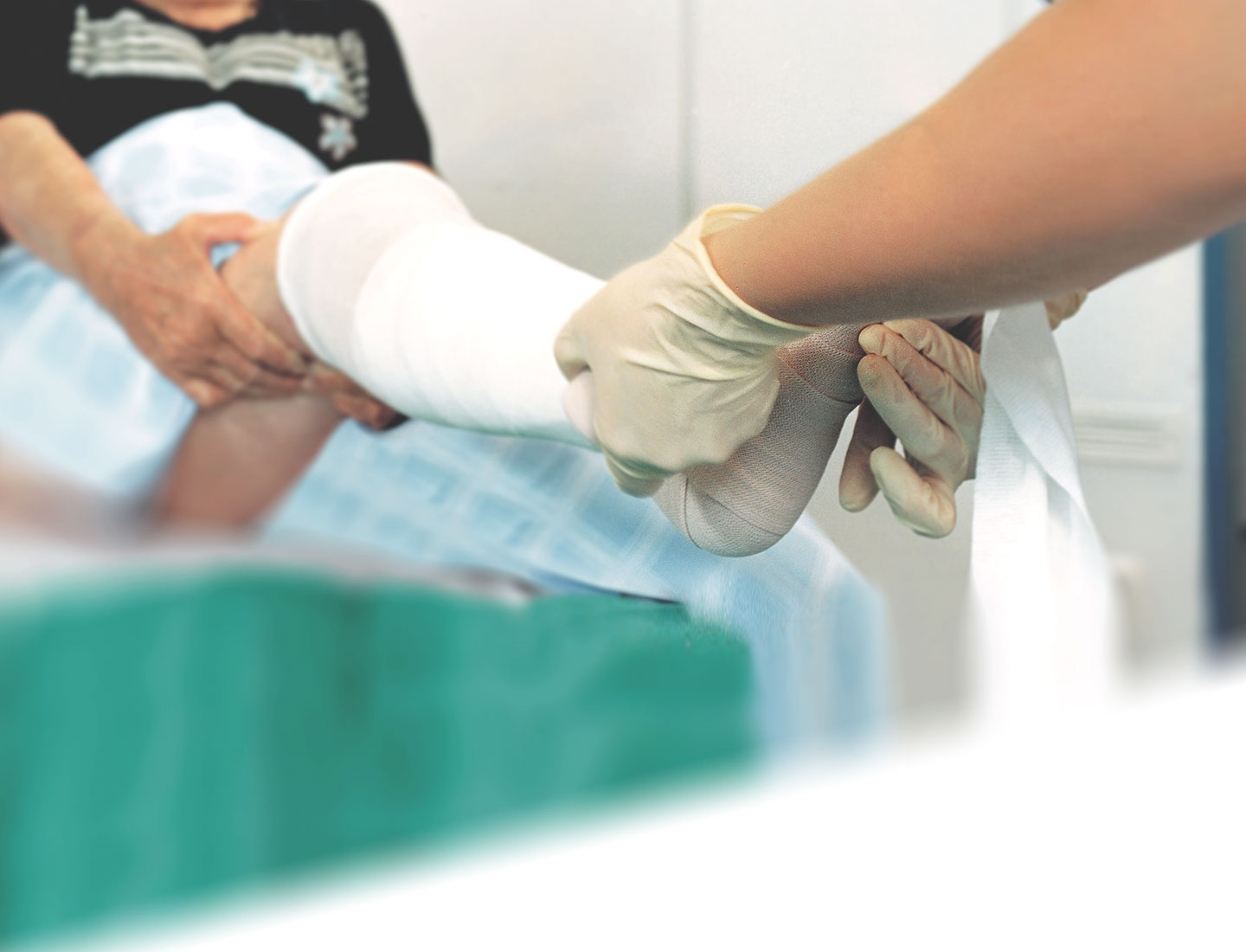 Arzthelferin verbindet Bein und Fuß einer Seniorin