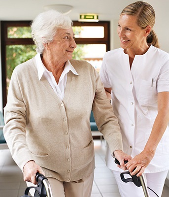 Ältere Frau am Rollator zusammen mit Pflegefachkraft