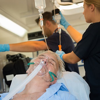 Senior mit Beatmung im Krankenwagen nach Schlaganfall