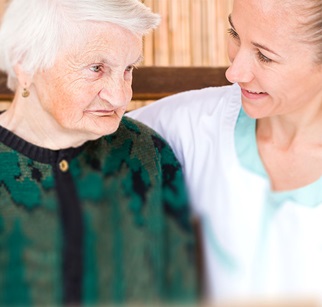 Pflegerin im Gespräch mit dementer Seniorin
