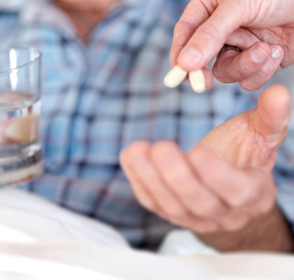 Pflegebedürftiger Senior bekommt Tabletten in die Hand gelegt