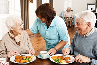 Senioren Paar mit Pflegerin beim Essen