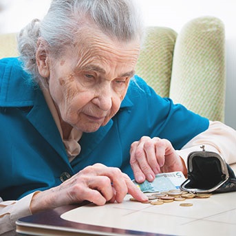Ältere Dame zählt Münzen