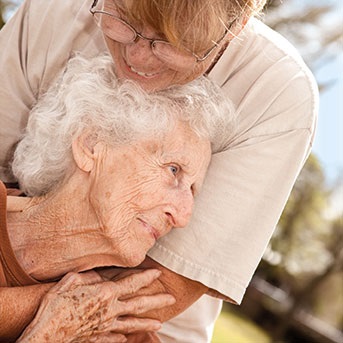Ältere Dame und Frau umarmen sich