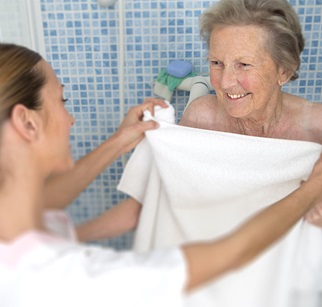 Pflegerin hilft älterer Dame aus der Dusche